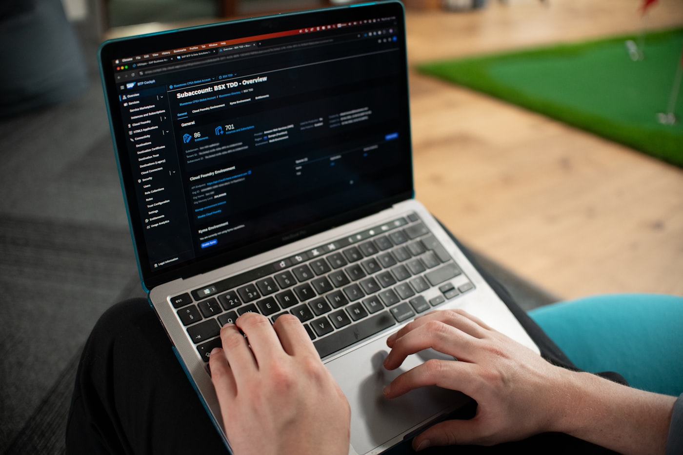 Close-up of hands typing on a laptop with a vibrant blue and teal glowing screen, representing SEO and web strategy work