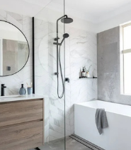 Modern renovated bathroom with a walk-in glass shower, photographed for an H Reno listing
