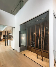 Modern renovated home interior with a glass-enclosed wine wall, photographed for an H Reno listing